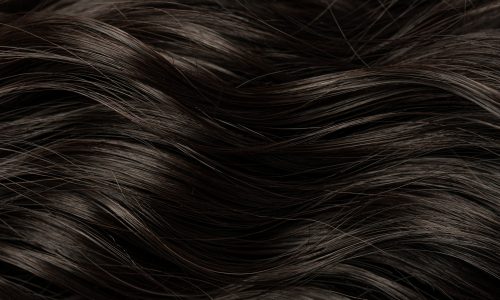 Dark curly long hair in close-up. A wave of hair as a background