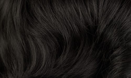 Close-up view of natural shiny dark hair, bunch of black brunette curls background
